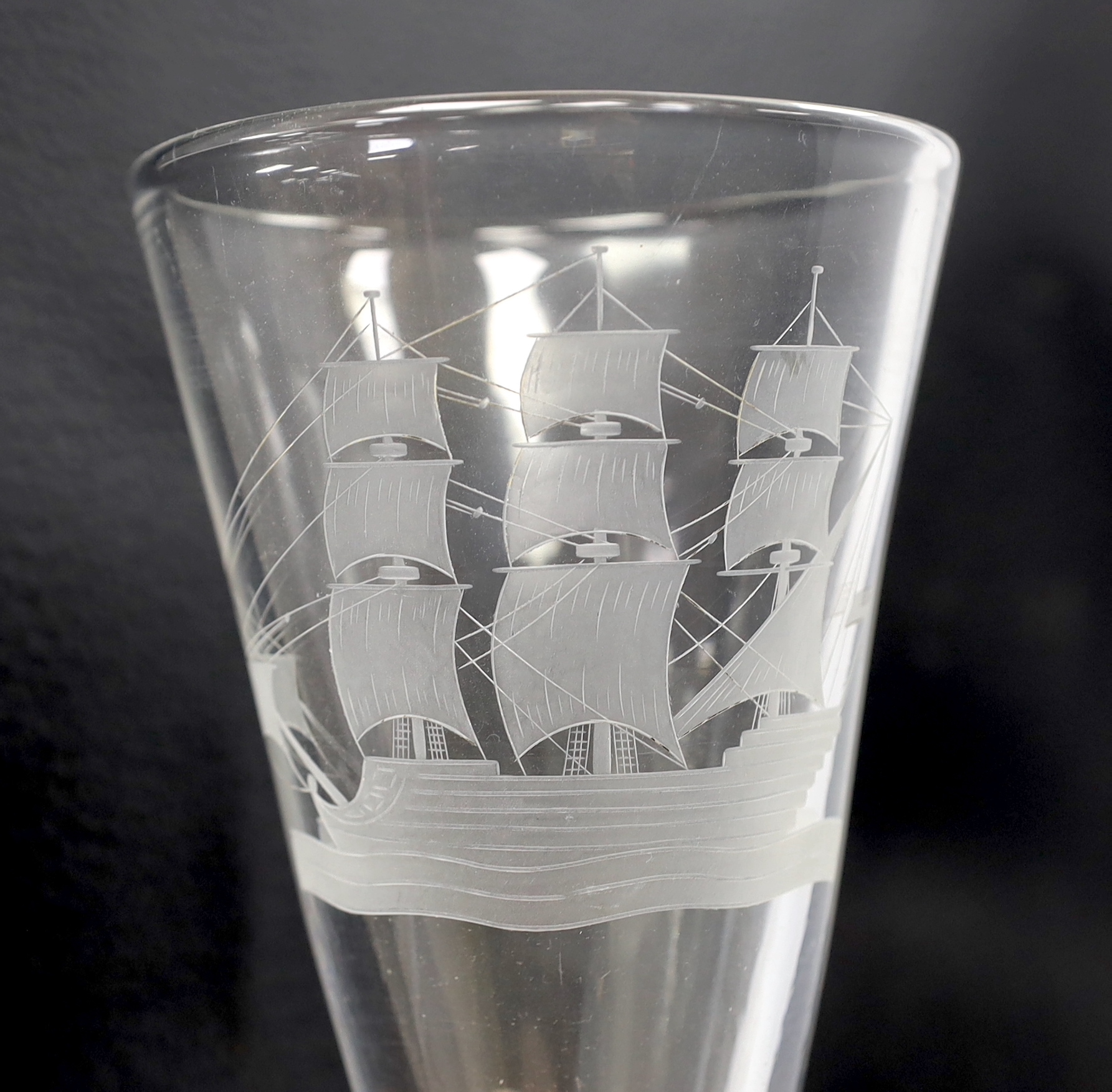 Eight 19th century drinking glasses including a large example with wrythen stem, etched with a naval ship, 27cm high